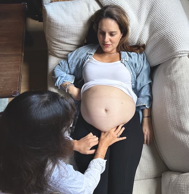 Midwife examining pregnant woman at home